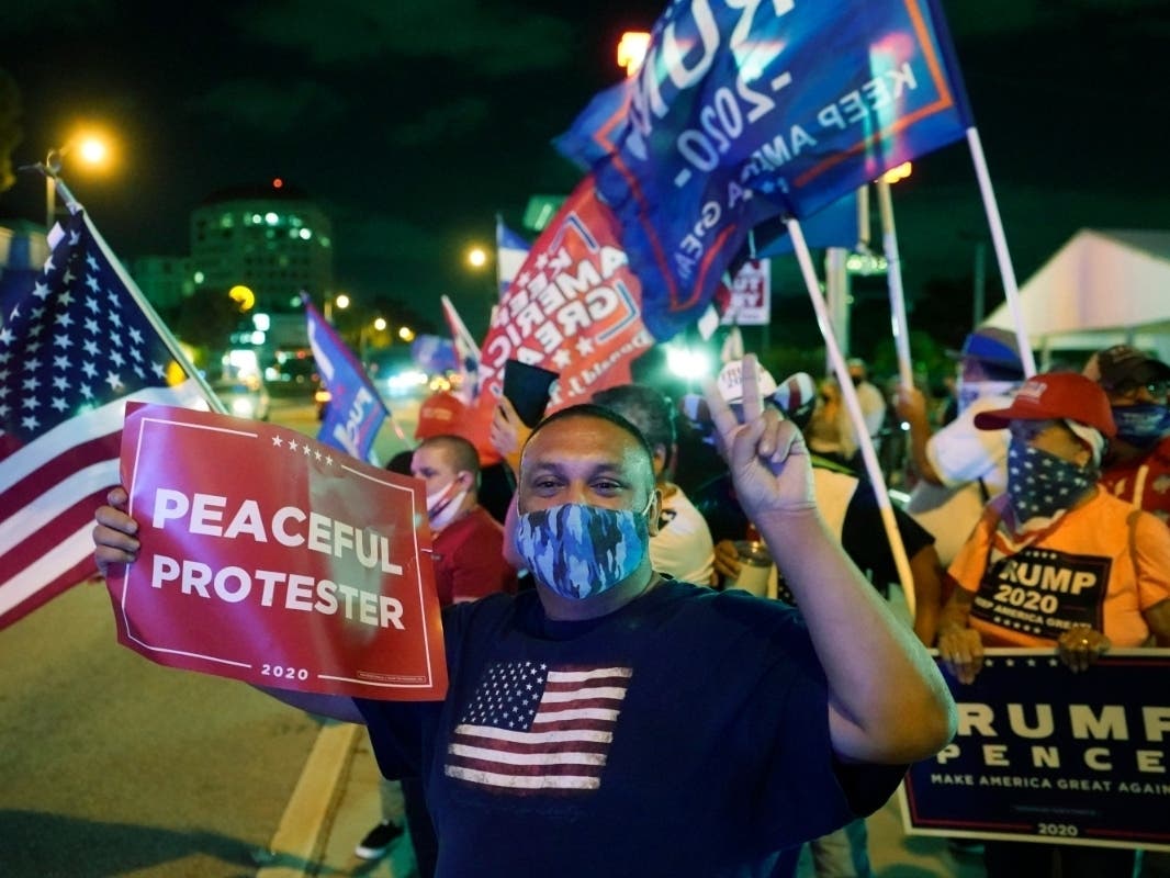 Supporters of President Donald Trump chant and wave flags outside the Versailles Cuban restaurant during an election night celebration in the Little Havana neighborhood of Miami. 