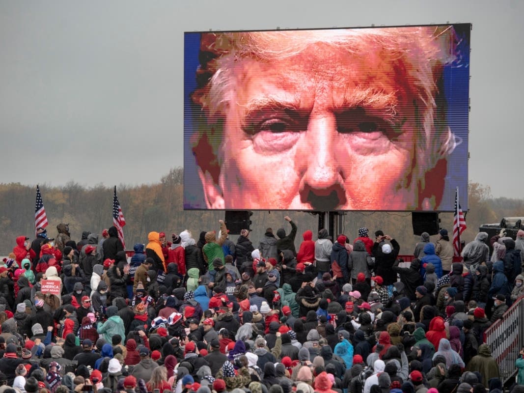 Supporters of President Donald Trump watch a video during a campaign event in Lansing, Michigan.