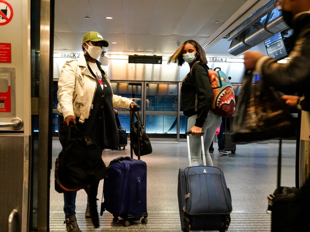 Travelers leave the AirTrain at JKF International Airport on Friday in New York.