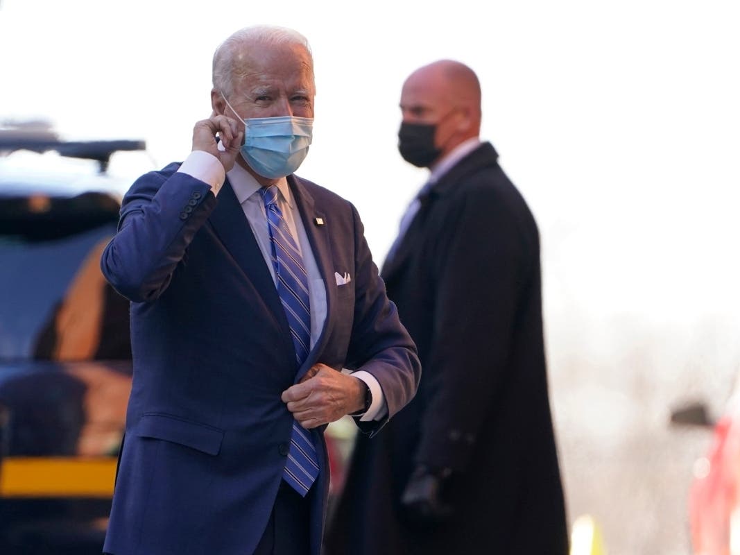 President-elect Joe Biden puts his finger on his ear as reporters shout question to him as he arrives at The Queen theater in Wilmington, Delaware on Monday.