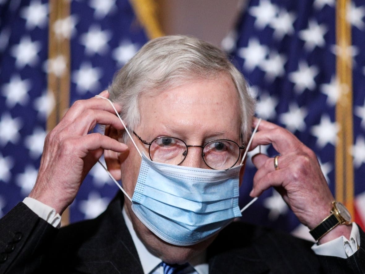 Senate Majority Leader Mitch McConnell of Kentucky removes his face mask as he arrives for a news conference with other Senate Republicans on Capitol Hill in Washington on Tuesday.