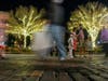 Linh and Van Dang take photos with their daughters Giovanna and Arianna as people walk down the street around them Friday, Dec. 11 during Christmas in a Railroad Town festivities in downtown Opelika, Alabama. 