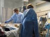 Nurse Jesse Phelps, left, works on a COVID-19 patient as a family member looks on at East Alabama Medical Center in the intensive care unit Thursday, Dec. 10 in Opelika, Alabama.