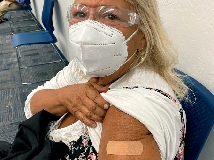 Terry Beth Hadler, 69, shows where she received a dose of a COVID-19 vaccine on Tuesday at a Bonita Springs, Florida, library where Lee County officials were administering the vaccine on a first come, first-served basis to people 65 or older.