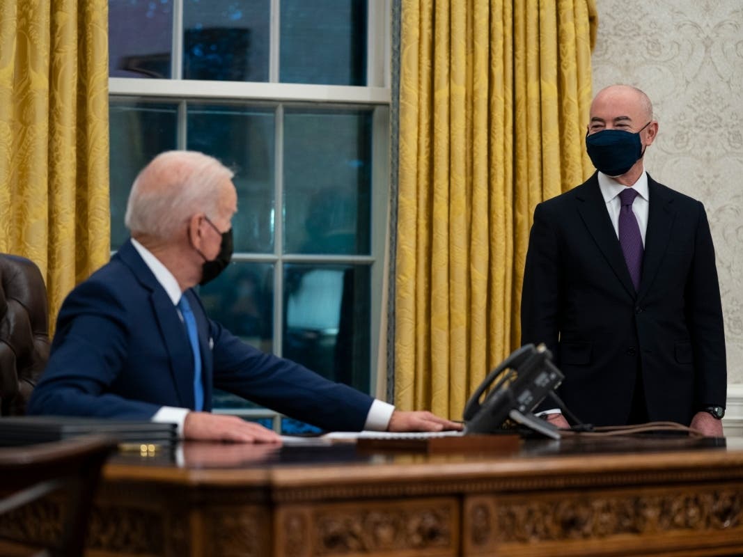Secretary of Homeland Security Alejandro Mayorkas listens as President Joe Biden speaks before signing an executive order on immigration.