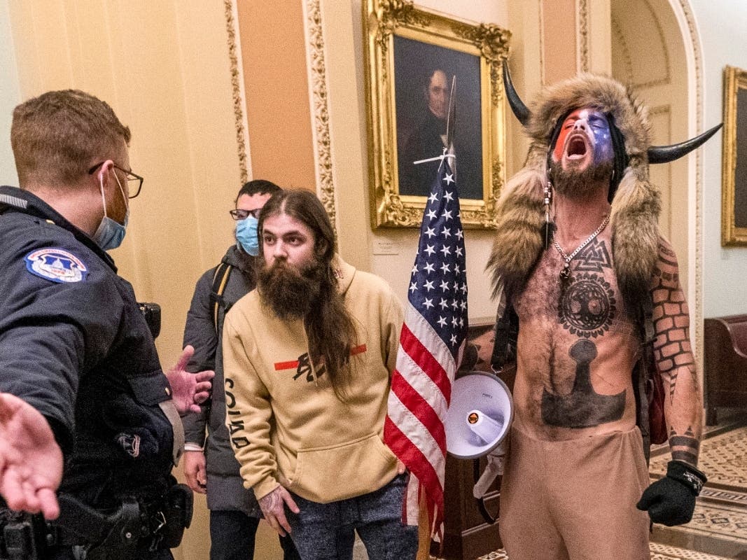  In this Wednesday, Jan. 6, 2021 file photo, supporters of President Donald Trump, including Jacob Chansley, right with fur hat, are confronted by U.S. Capitol Police officers outside the Senate Chamber inside the Capitol in Washington.