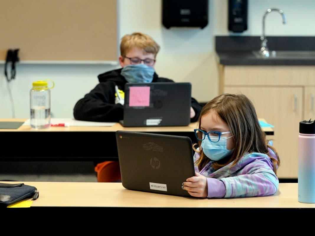 In this file photo, students wear masks as they work in a fourth-grade classroom, at Elk Ridge Elementary School in Buckley, Wash. 
