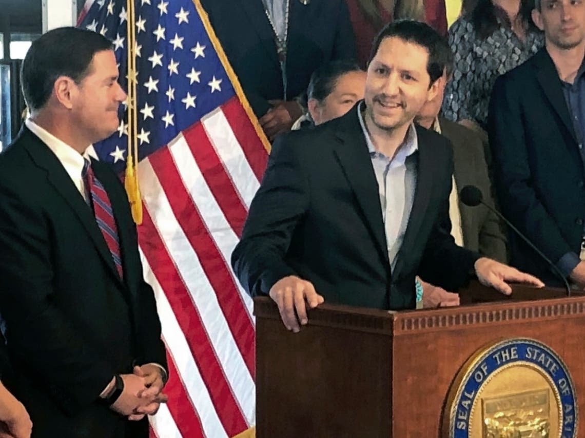 In this May 28, 2019 file photo Arizona Republican Sen. Paul Boyer, at the podium, is seen with Arizona Gov. Doug Ducey during a news conference in Phoenix.