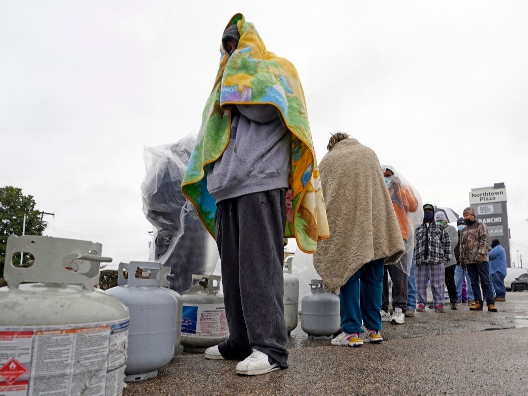 Carlos Mandez waits in line to fill his propane tanks Wednesday, Feb. 17, 2021, in Houston.