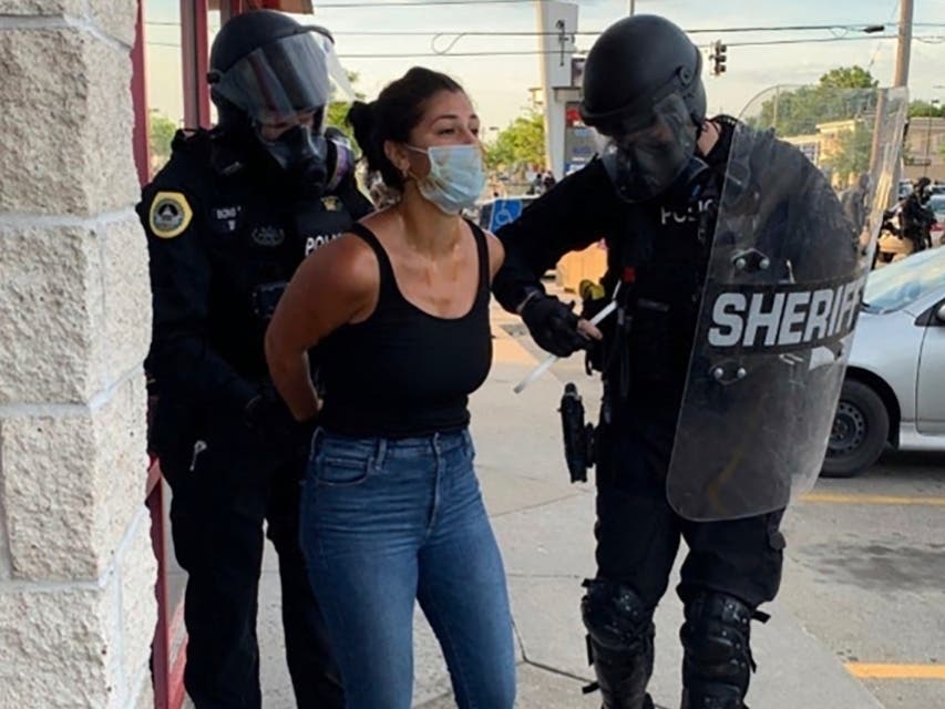Police officers are shown arresting Des Moines Register reporter Andrea Sahouri after a Black Lives Matter protest she was covering on May 31, 2020, in Des Moines, Iowa, was dispersed by tear gas.