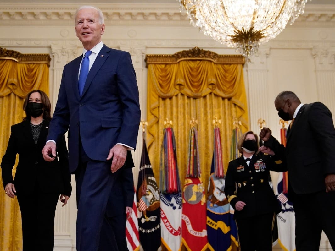 President Joe Biden leaves with Vice President Kamala Harris and Defense Secretary Lloyd Austin after speaking during an event to mark International Women's Day.