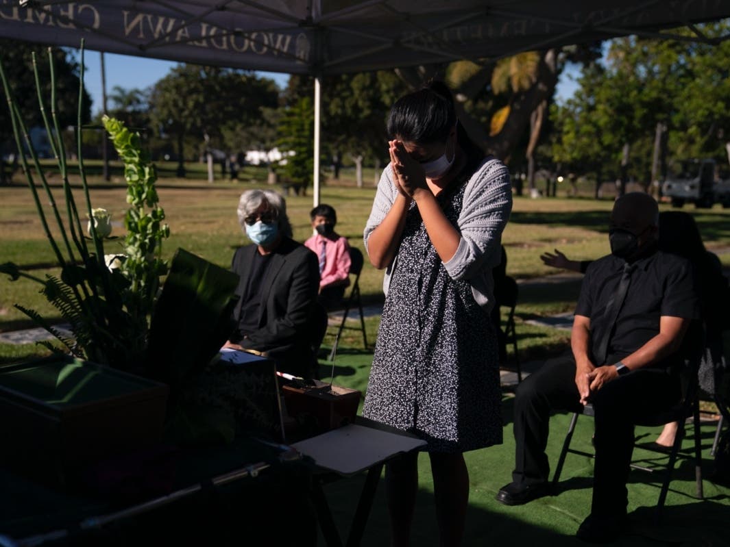 Lilah Matsumura, 11, prays for for her great-grandfather, Giichi Matsumura, during a memorial service at Woodlawn Cemetery in Santa Monica, Calif., Monday, Dec. 21, 2020. 