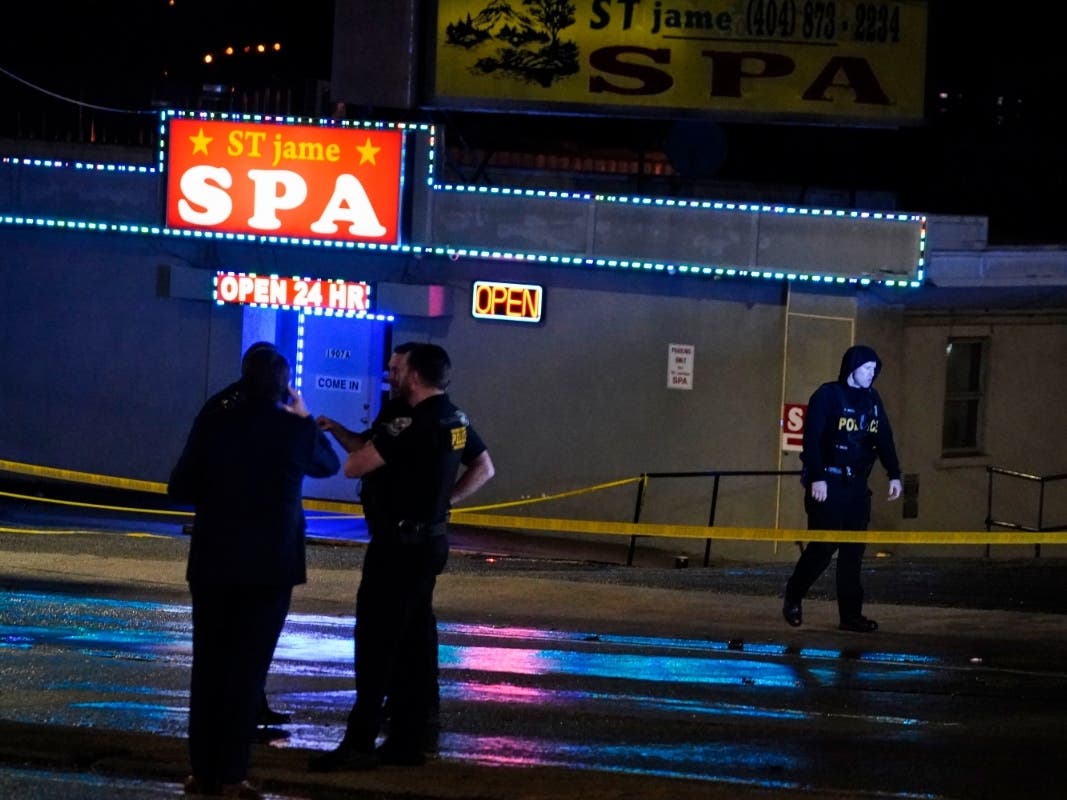 Law enforcement officials confer outside a massage business following a shooting in Atlanta.