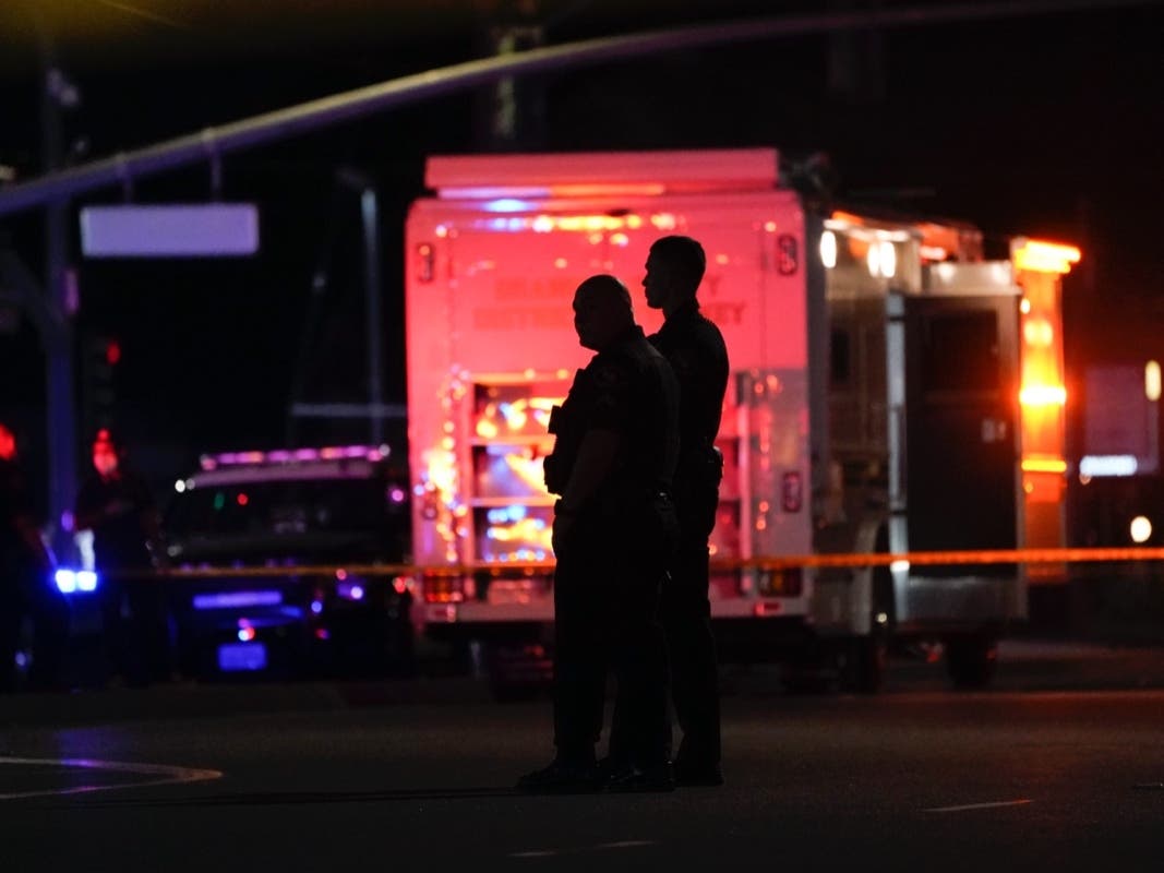 Two police officers stand outside an office building where a shooting occurred in Orange, Calif., Wednesday, March 31, 2021. 