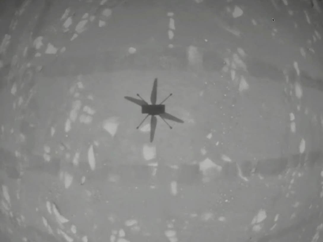 The experimental Mars helicopter Ingenuity casts a shadow as it hovers above the surface of the planet on Monday, April 19, 2021.