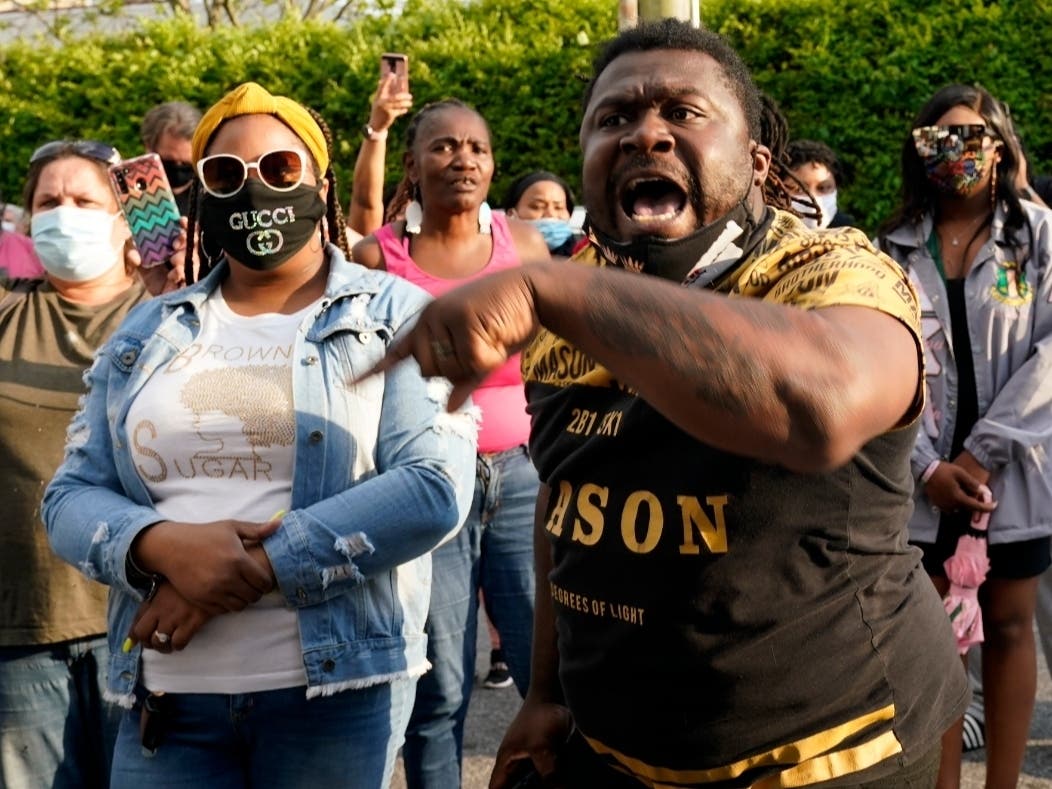 People gather outside the municipal building after at least one Pasquotank County Sheriff's deputy shot and killed a Black man while executing a search warrant, the sheriff's office said, Wednesday, April 21, 2021, in Elizabeth City, N.C. 
