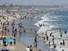 In this July 12, 2020, file photo, visitors crowd the beach in Santa Monica, Calif., amid the coronavirus pandemic. Californians headed to campgrounds, beaches and restaurants over the long holiday weekend.