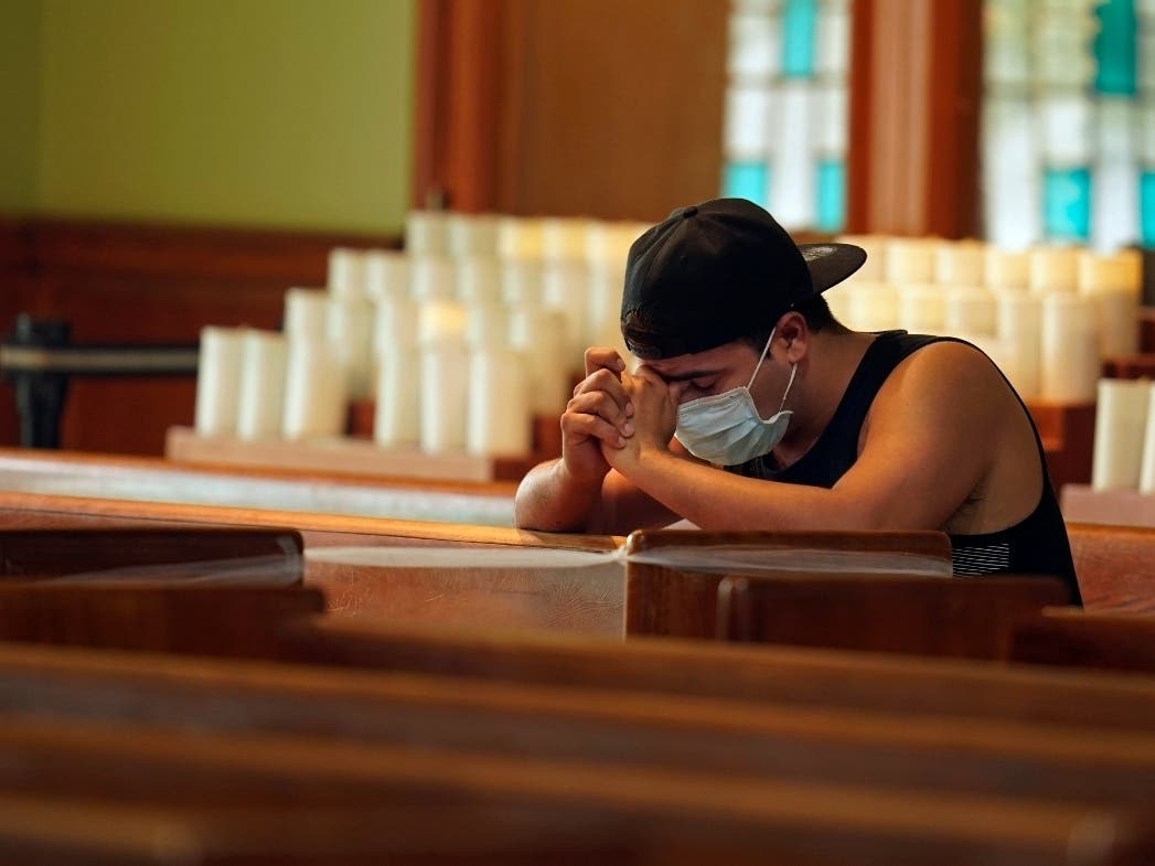 A man prays during vespers at St. Joseph's Catholic Church in Miami Beach. President Joe Biden will Surfside on Thursday to meet with first responders, rescue crews and family members of the nearly 150 people still missing after the condo collapse.