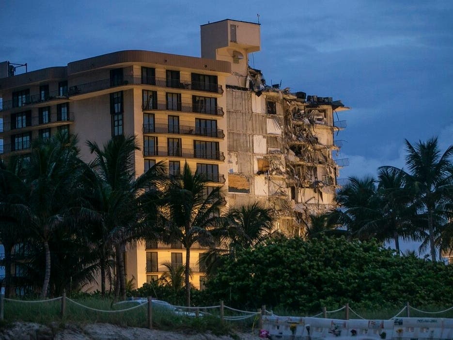 Light shines on the Champlain Towers South as search and rescue teams continue looking for survivors of the partially collapsed residential building in Surfside, Florida. 