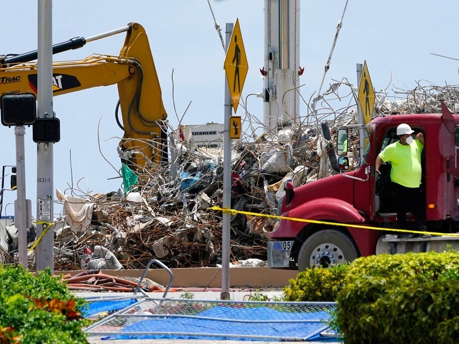 A worker waits to load his truck with debris from the rubble of the Champlain Towers South building, as removal and recovery work continues at the site of the partially collapsed condo building,