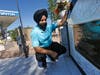 In this Aug. 19, 2016 file photo, Rana Singh Sodhi, kneels near his service station in Mesa next to a memorial for his brother, Balbir Singh Sodhi, who was murdered in the days after the Sept. 11 terrorist attacks.