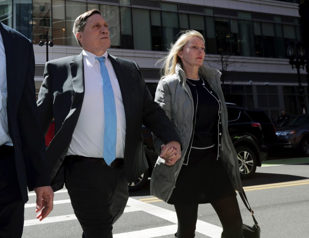Investor John Wilson, left, arrives at federal court in Boston with his wife Leslie to face charges in a nationwide college admissions bribery scandal in April 2019. The first trial stemming from Operation Varsity Blues opens Wedneday.
