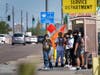 People stand in the direct sunlight adjacent to an over-crowded bus stop in September in Phoenix. Soaring temperatures are making it harder to live in the United States' already hot, fast growing desert areas. 
