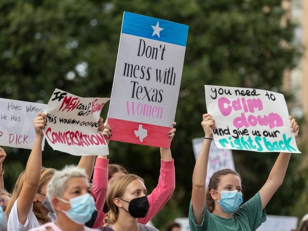 In this Oct. 2, 2021, file photo, people attend the Women's March ATX rally, at the Texas State Capitol in Austin, Texas. A federal judge has ordered Texas to suspend a new law that has banned most abortions in the state since September. 