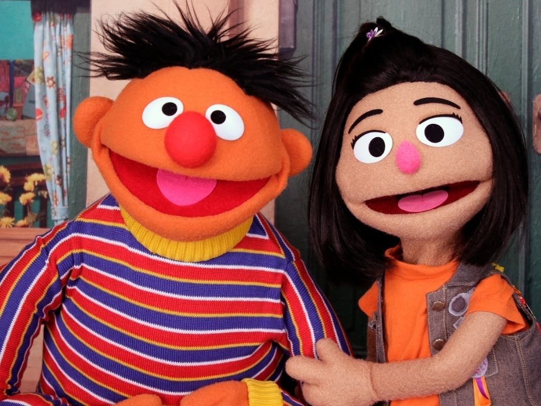 Ernie, one of the "Sesame Street" Muppets, appears with Ji-Young, the first Asian American Muppet, on the set of the long-running children's program. Ji-Young, a Korean American, has two passions: rocking out on her electric guitar and skateboarding.