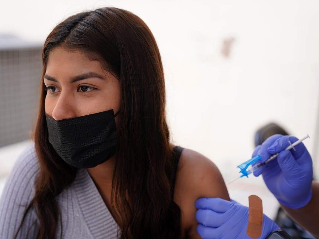 A young woman from Tijuana, Mexico, receives a vaccination shot against the coronavirus outside of the Mexican Consulate building, Thursday, Nov. 18, 2021, in San Diego. Scores of Mexican adolescents were bused to San Diego on Thursday to get vaccinated. 