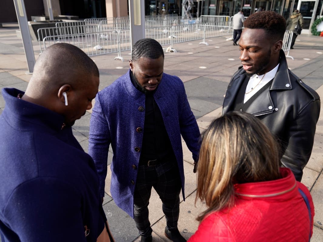 Abimbola Osundairo, right, prays with his brother Olabinjo Osundairo, center, a bodyguard, left, and their attorney Gloria Schmidt Rodriguez before heading into court Thursday in Chicago.