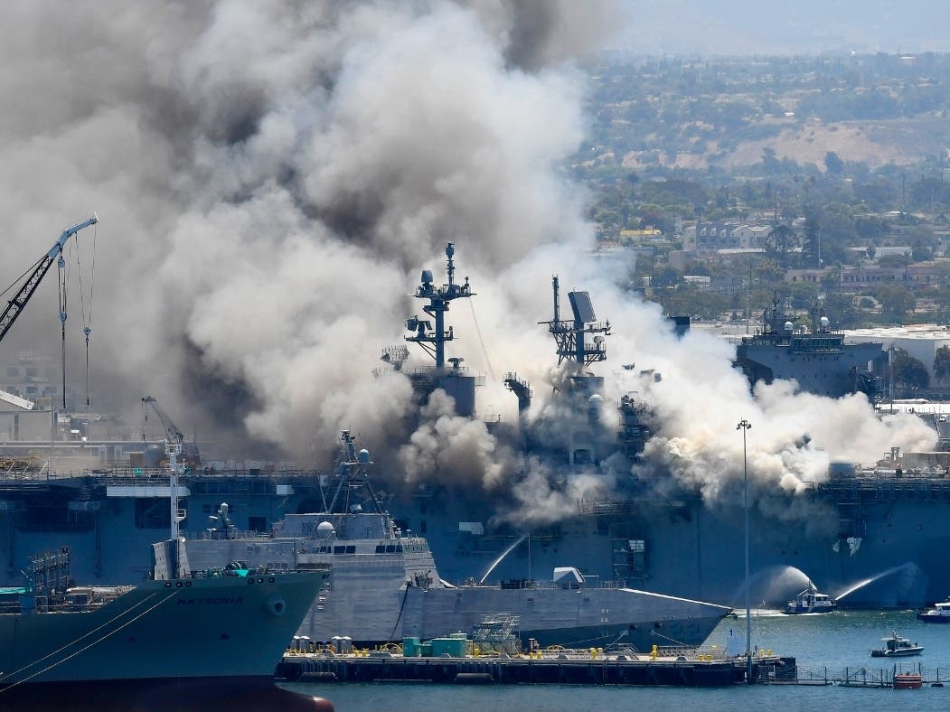 In this July 12, 2020, file photo, smoke rises from the USS Bonhomme Richard after an explosion and fire on board the ship at Naval Base San Diego. 
