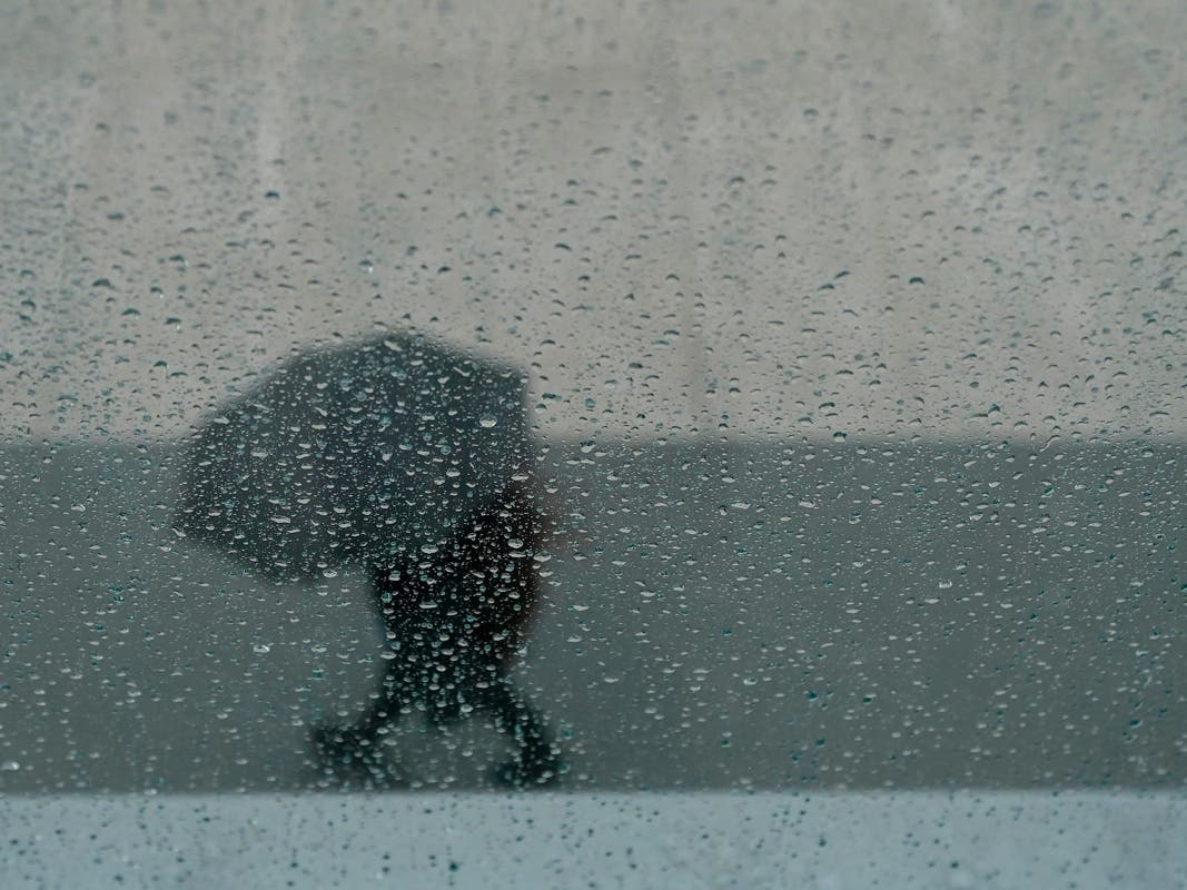 A pedestrian walks with an umbrella outside of the Chase Center in San Francisco.