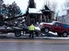 A car is towed that the Marshall Fire spared in Louisville. Behind the car is the burned home.