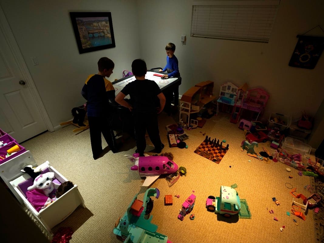 Mick Leichenko, center, entertains friends Jack and Will Marrion on Thursday in his Chicago home. Talks between Chicago school leaders and the teachers union resumed Sunday amid a standoff over remote learning and other COVID-19 safety measures.