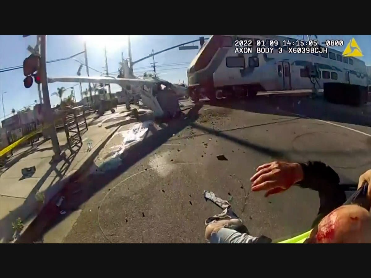 In this screen grab from a body cam video provided by the Los Angeles Police Department, a commuter train crashes with a plane which had just taken off from nearby Whiteman Airport Sunday, Jan. 9, 2021 in Pacoima, Calif.