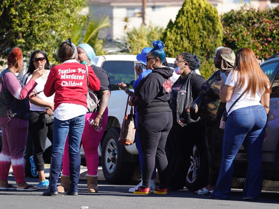 People gather on Park Avenue near the scene of a shooting in Inglewood, Calif., on Sunday.