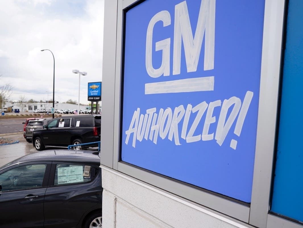 In this May 2, 2021, file photo, a General Motors sign hangs on the side of a Chevrolet showroom in Englewood, Colo. Michigan's economic development board on Tuesday, Jan. 25, 2022 approved $824 million in incentives and assistance for General Motors Co.