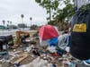 A trashed punching bag is left at a homeless encampment on the side of the CA-101 highway in Echo Park neighborhood in Los Angeles Tuesday, May 11, 2021