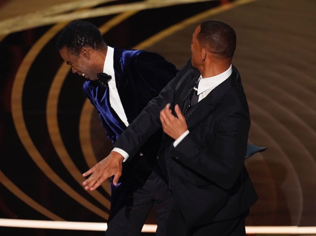 Will Smith, right, hits presenter Chris Rock on stage while presenting the award for best documentary feature at the Oscars on Sunday.