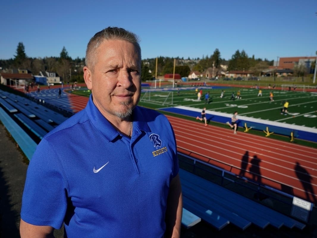 Joe Kennedy, a former assistant football coach at Bremerton High School in Bremerton, Wash., poses for a photo March 9, 2022, at the school's football field.