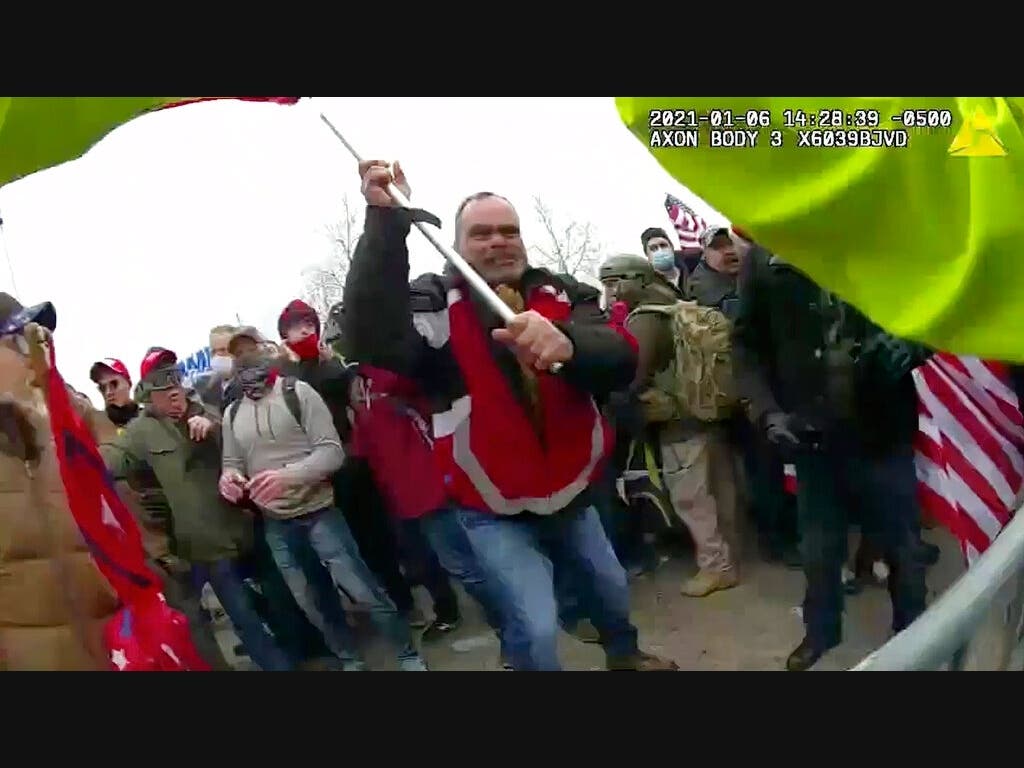 This still frame from Metropolitan Police Department body-worn camera video shows Thomas Webster, in red jacket, at a barricade line at the U.S. Capitol Jan. 6, 2021. Webster was convicted of assault despite arguing self-defense. (via AP, File)