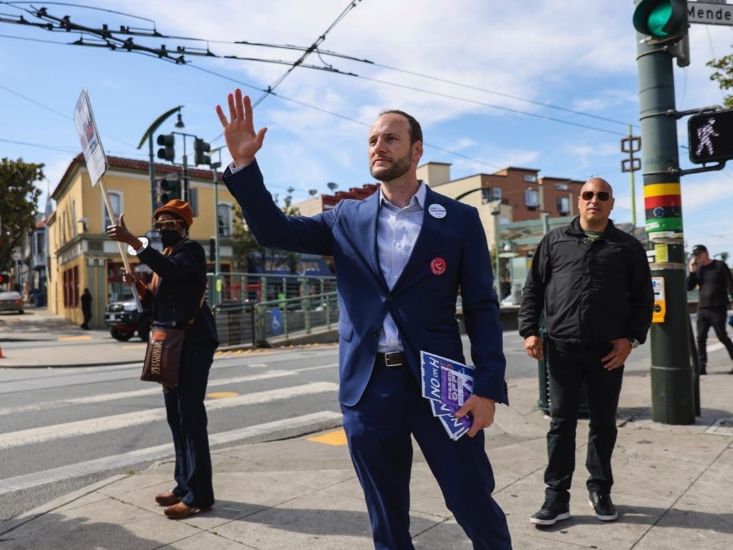 District Attorney Chesa Boudin waves at cars honking in support as he canvasses on 3rd Street in the Bayview neighborhood ahead of the recall on Tuesday, June 7, 2022, in San Francisco. 