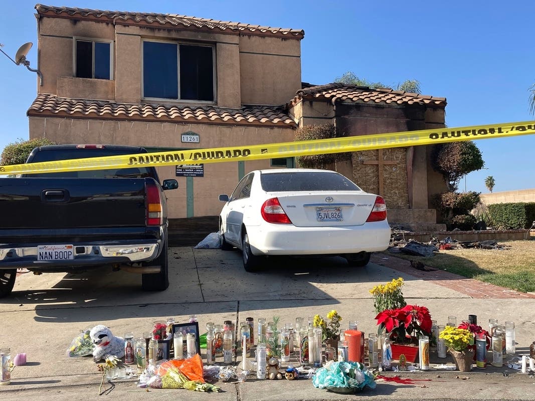  Dozens of candles sit placed on the sidewalk along with bouquets of flowers and stuffed animals outside a charred home in Riverside, Calif., Wednesday, Nov. 30, 2022. 