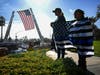 Cynthia Salazar, and daughter, Rosalynn Salazar, 7, of Corona, stand along the route to honor slain Riverside County Sheriff Deputy Isaiah Cordero as the hearse carrying his body passes by on Friday, Jan. 6, 2023, in Riverside.