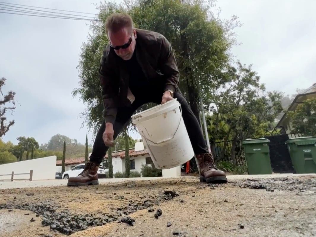 This video still image provided by The Office of Arnold Schwarzenegger, shows former California Governor Arnold Schwarzenegger, repairing a pot hole on a street in his Los Angeles neighborhood on Tuesday, April 11, 2023.