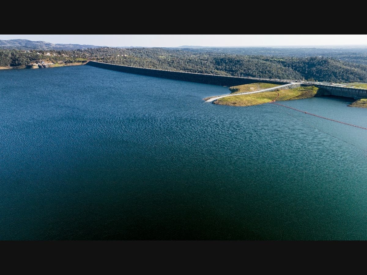 The Oroville Dam, top right, holds back water at Lake Oroville on March 25, 2023, in Butte County, Calif. Regulators say California will provide 100% of the water requested by cities and farms for the first time in years thanks to winter storms.