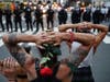 Protesters kneel in front of New York City Police Department officers before being arrested for violating curfew beside the iconic Plaza Hotel on 59th Street, June 3, 2020, in New York.