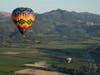 A pair of balloons make their way above the Dominus Estate winery and Highway 29, seen from a Napa Valley Aloft balloon, in Yountville, Calif., Monday, June 19, 2023. 