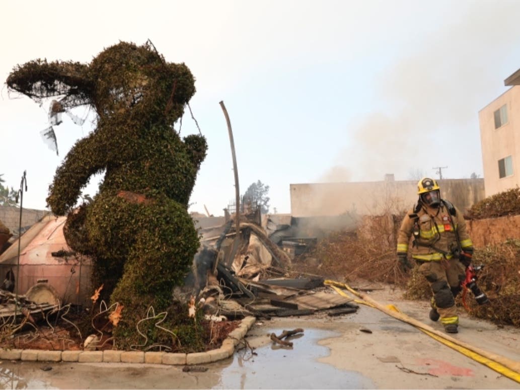 A firefighter walks past a charred bunny sculpture and debris at the destroyed Bunny Museum, Thursday, Jan. 9, 2025, in the Altadena section of Pasadena, Calif.